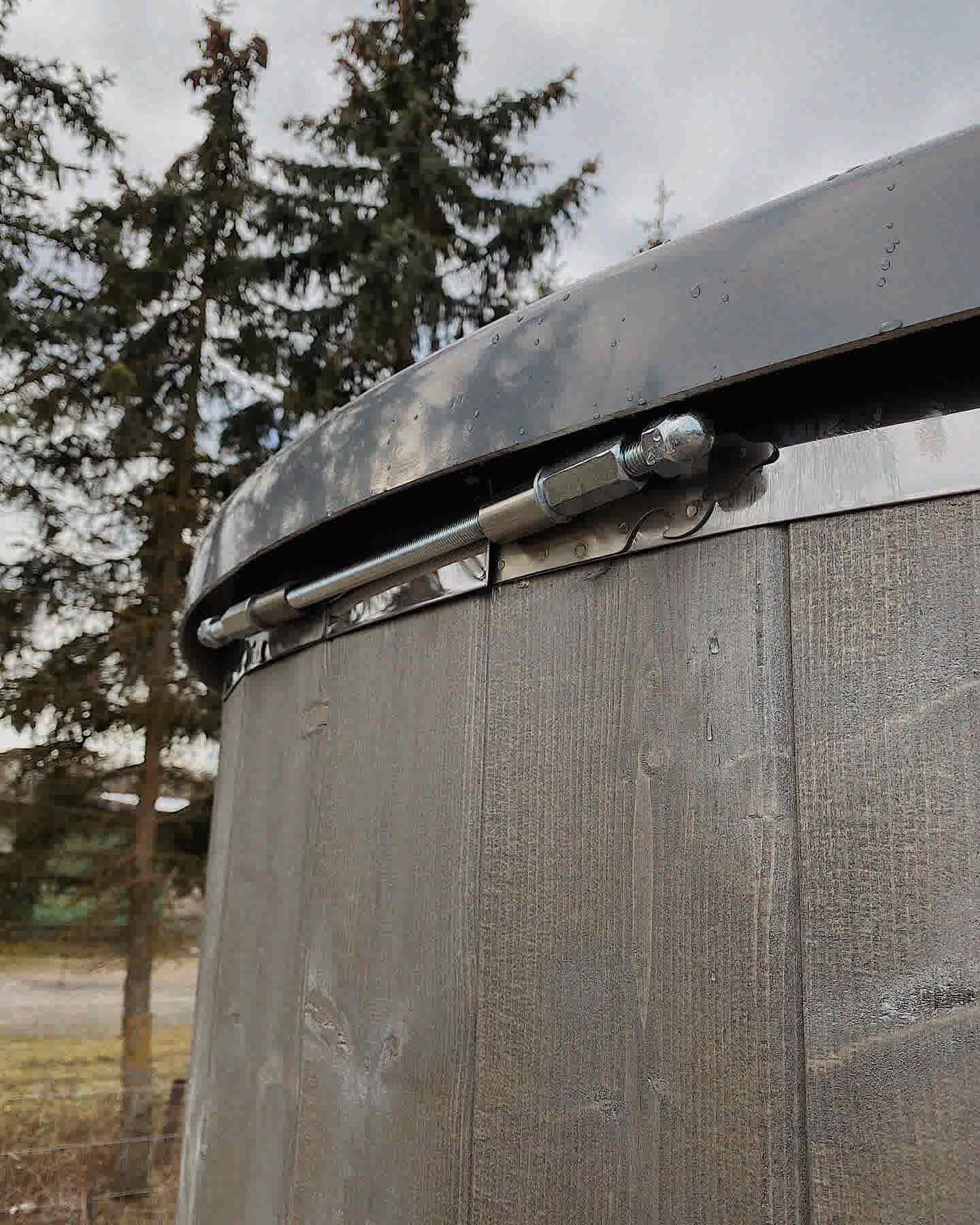 Detail shot of the heavy-duty stainless steel tension bands and hardware on a Terra Sauna barrel model.