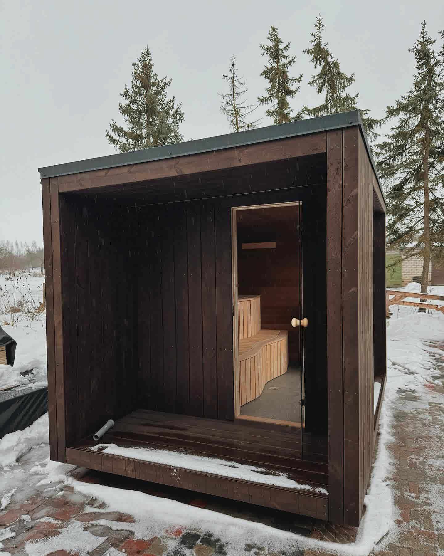 The Cubus modern sauna entrance with a floor-to-ceiling glass door and recessed covered porch area.